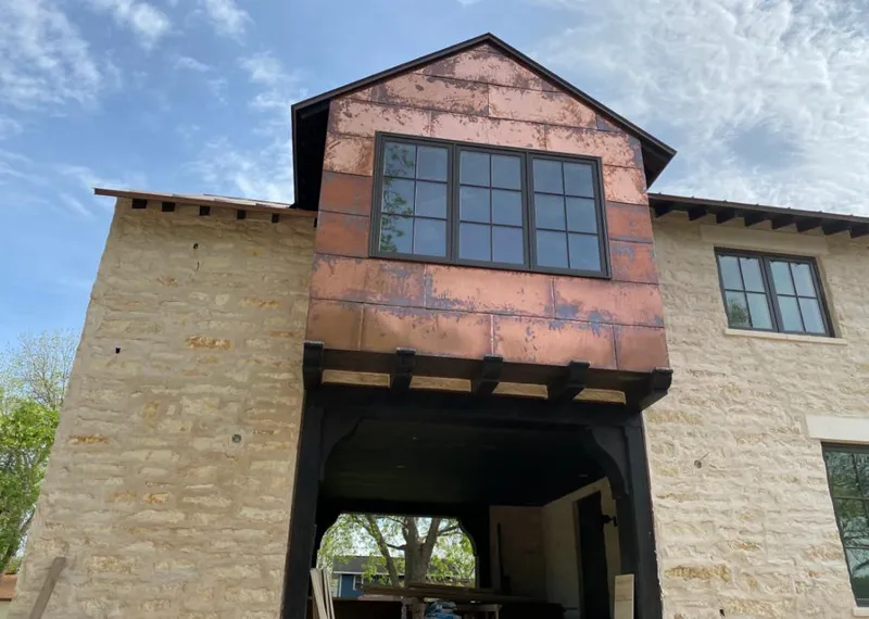 Copper metal panel facade on a stone building for Roof Repair in Colville